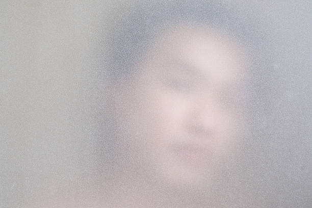 Close-up a man face behind frosted glass