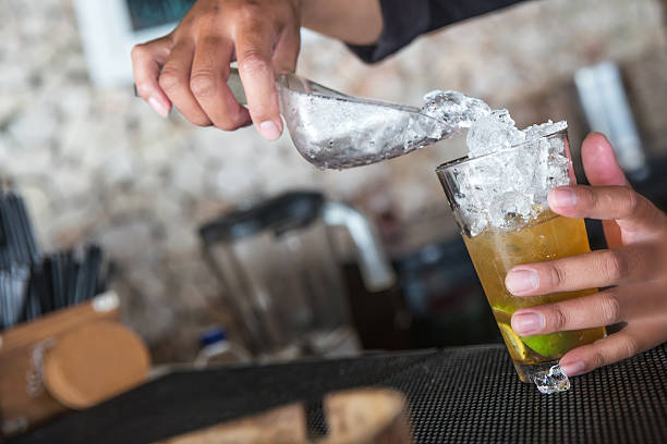 istock Male bartender pouring ice cube on a glass 545780834