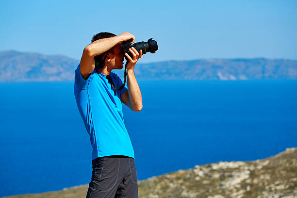 istock photographer on the cliff at sea background 545782448