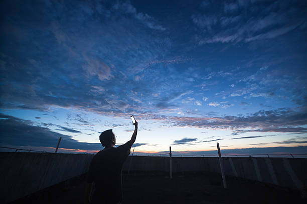 istock man with phone up to the universe 545785830