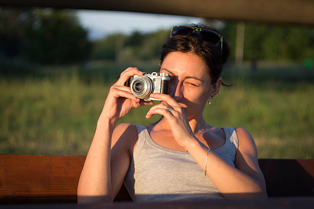 istock Hipster girl with retro camera taking a photo. 545787228