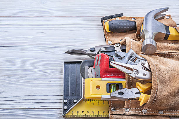 istock Building implements in leather tool belt on wooden board constru 545788108