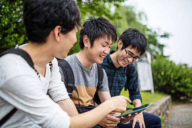 デジタルタブレットで一緒に働く日本人学生 - learning male studying smiling ストックフォトと画像