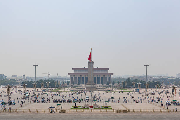 View of the Tiananmen square of Beijing Beijing, China - Jun 20, 2016 : Veiw of the Tiananmen square from the Tiananmen gate. Temporarily clear skies over Beijing but still haze and smog in the air. Travelers are walking and taking pictures at the square on a sunny summer day. tiananmen square stock pictures, royalty-free photos & images