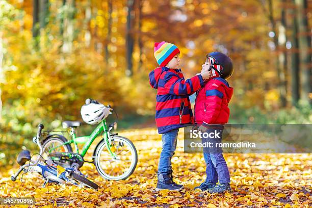 Two Little Kid Boys With Bicycles In Autumn Park Stock Photo - Download Image Now - Autumn, Child, Assistance