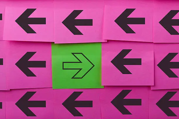 Arrows. Opposite concept. Background of pink sticky notes.