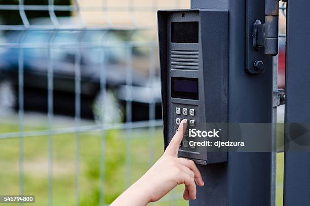 Little Child Boy Pushes A Button On The Intercom Stock Photo - Download Image Now - Gate, Intercom, Security