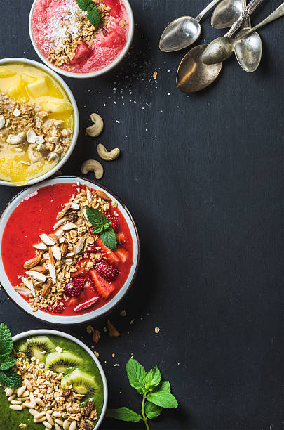 istock Healthy summer breakfast concept. Colorful fruit smoothie bowls with nuts 545799072