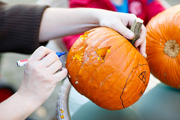 istock Hollowing out a scary pumpkin to prepare halloween lantern 545802866