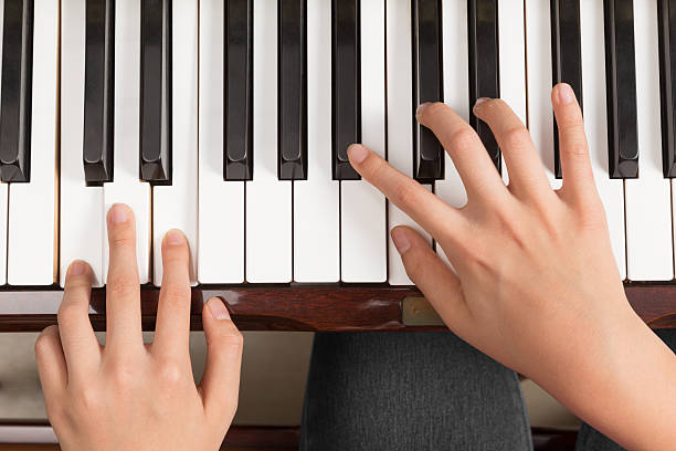 istock Top view close up of female hands playing piano 545802890