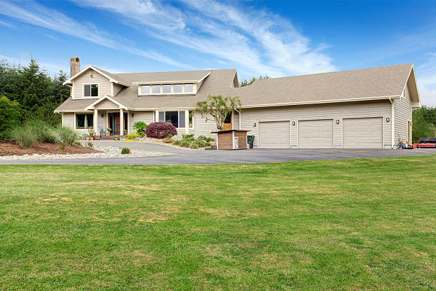 istock Large beige house with white trim, and well kept lawn 545803914