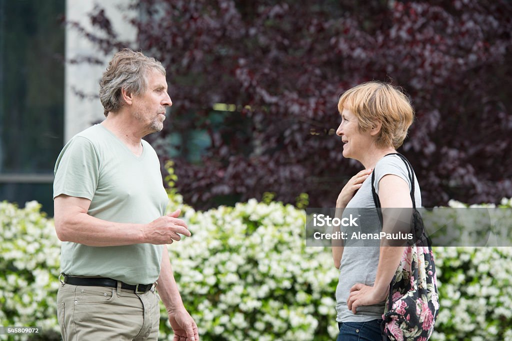 Senior caucasian couple talking outdoors in city park Senior caucasian couple talking outdoors in city park;  Slovenia, Europe. All logos removed. Nikon D800, full frame, Nikkor 70.0-200.0 mm, aperture 2.8, Copy space. 50-54 Years Stock Photo