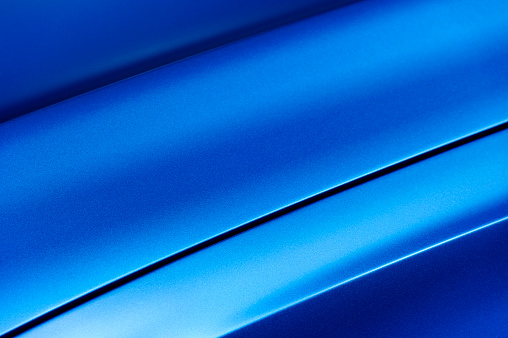 Surface of blue sport sedan car metal hood, part of vehicle bodywork, steel gradient line pattern 