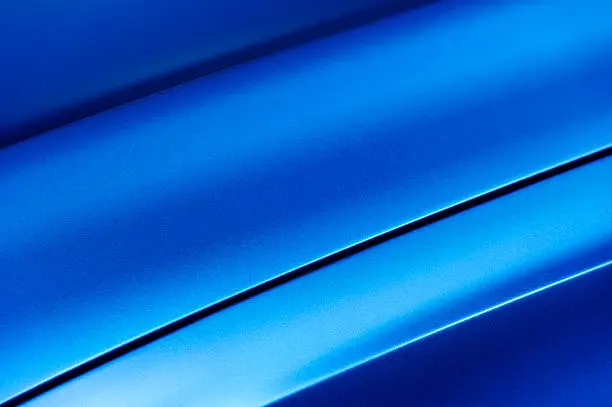 Surface of blue sport sedan car metal hood, part of vehicle bodywork, steel gradient line pattern 