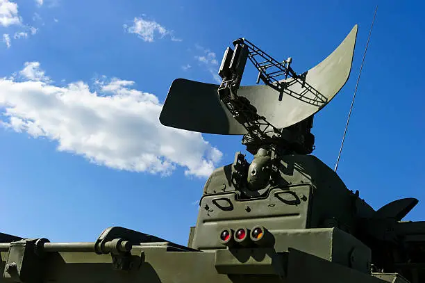 Air defense radar of military mobile mighty missile launcher system of green color, modern army industry, white cloud and blue sky on background 