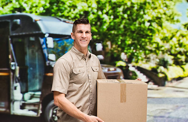istock Smiling worker holding box outdoors 545811856