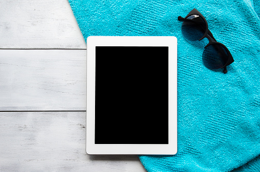 Digital tablet with a blank screen on white wooden floor