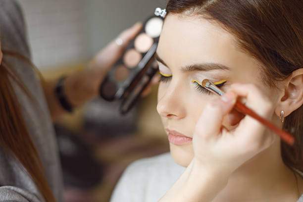 istock Young woman applying makeup to model in salon 545820120
