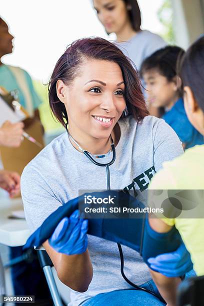 Beautiful Volunteering Nurse Checking Blood Preasure Stock Photo - Download Image Now