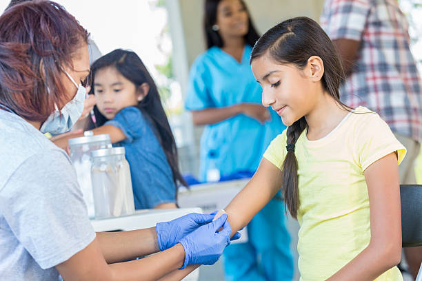 istock Hispanic girl getting a bandaid after she received a shot 545980310