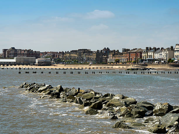 Lowestoft, Suffolk, England - June 9, 2016: Rows of boarding houses and hotels along Kirkley Cliff Road on Lowestoft seafront. Lowestoft is a popular holiday resort in Suffolk, eastern England. (Background people.)