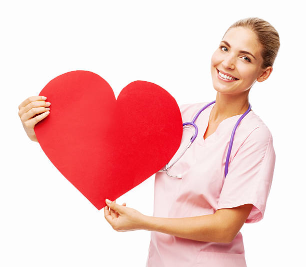 Confident Female Nurse Holding Heart Shape stock photo
