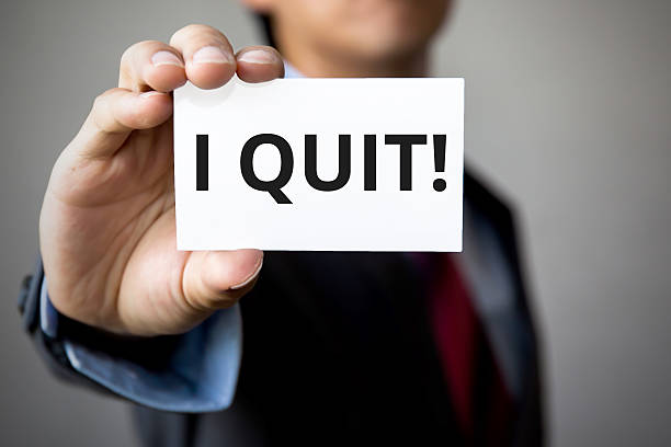 Businessman presenting 'I Quit' word on white card stock photo