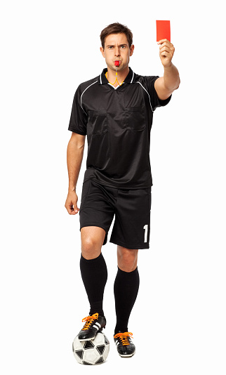 Serious woman, soccer referee gesturing, raising hand forward , stopping game and showing red card against white studio background. Concept of sport, competition, match, profession, football game