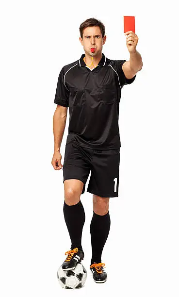 Full length portrait of referee with soccer ball showing red card over white background. Vertical shot.