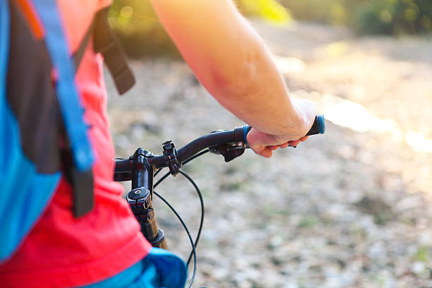istock Young man with backpack on the bicycle by mountain river 545984344