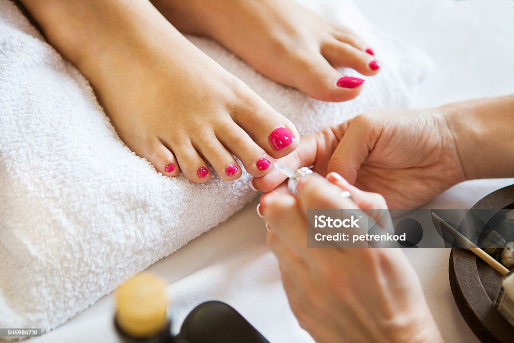 Frau im Nagelstudio erhält Pediküre von Kosmetikerin - Lizenzfrei Fußpflege Stock-Foto