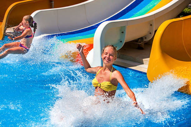 zwei kinder auf der wasserrutsche im aquapark. - amusement park family water slide child stock-fotos und bilder