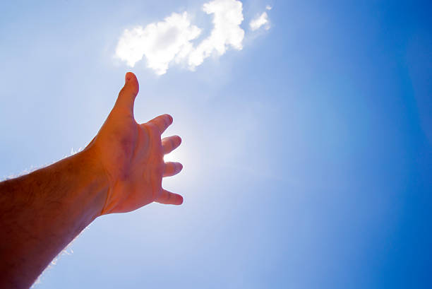 istock praying, Hand Reaching For The Sun 545985728
