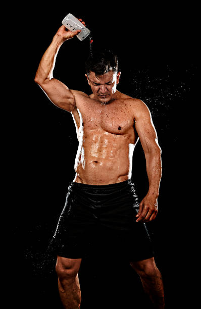 istock strong sportsman pouring water on his face sweating training hard 545987612