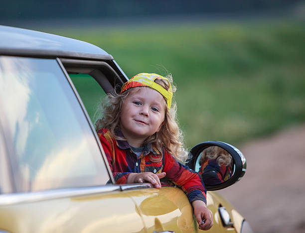 istock Happy little kid looking out from the yellow car 545988086