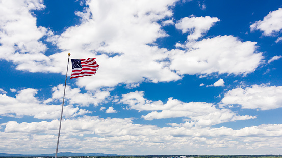 American flag with clouds and Appalachian mountains in background.