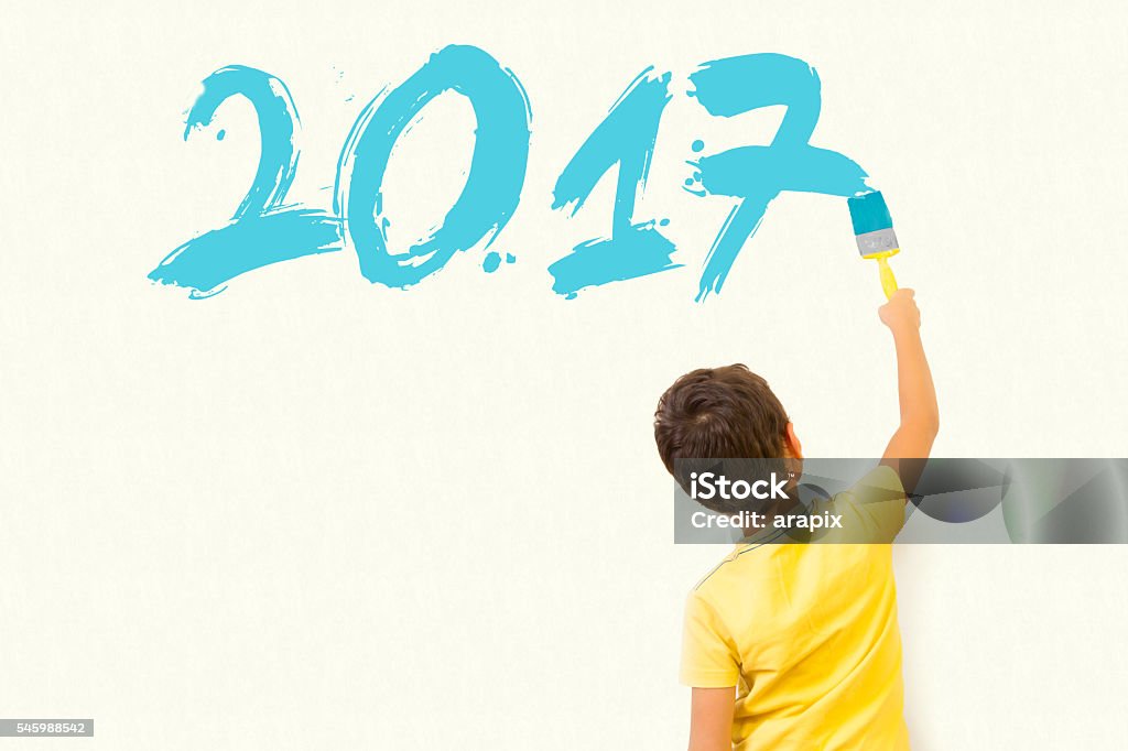 Cute little kid drawing new year 2017 Cute little kid drawing new year 2017 with painting brush on wall background 2016 Stock Photo