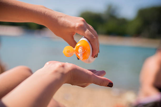 istock woman applying Suntan lotion 545989092