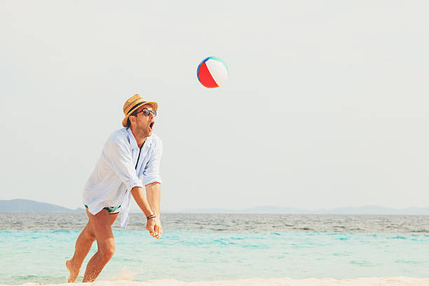 istock Young man playing on the beach with a ball 545989848