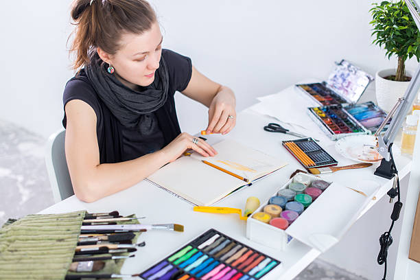 istock Young female artist drawing sketch using sketchbook with pencil at 545990370