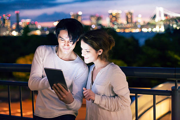 istock Couple standing on terrace and using digital tablet at night 545990714