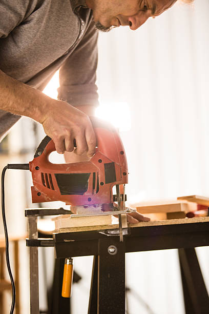 istock Male woodworker cutting a piece of wood using a jigsaw 545991050