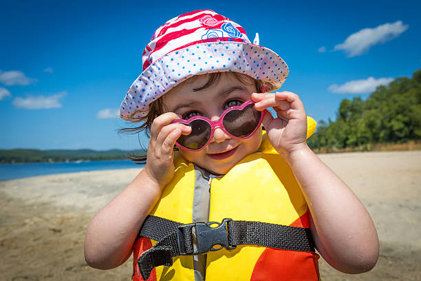 istock Child Wearing Yellow Life Jacket on Summer Beach 545992546