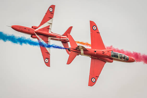 Red Arrows - Synchro Pair Fairford, UK - July 9, 2016: two British Aerospace Hawk jet training aircraft of the Red Arrows military display team pictured in flight over Gloucestershire, England.  british aerospace stock pictures, royalty-free photos & images