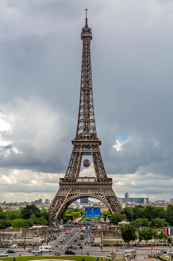 Paris, France - June 17, 2016: The Famous Eiffel Tower of Paris during the EUFA Euro 2016 tournament.  There is a huge football hung on the tower itself and in the distance you can clearly see the fan park where fans can watch all the matches from the tournament.