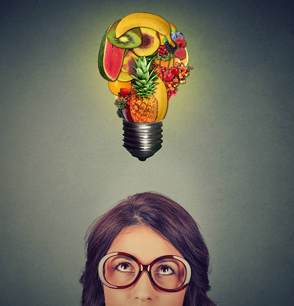 istock Eating healthy concept. woman looking at fruit light bulb 545997818