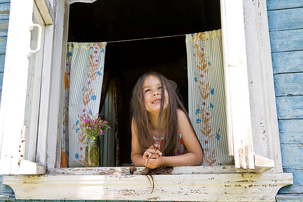 istock Laughing joyful little girl looking out from window wide open 546001036