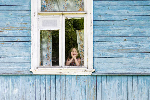 istock Sad girl looking out window leaning her face on hands 546001404