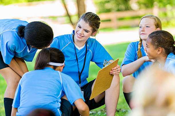 istock Pretty coach smiling at her players huddled together 546002212