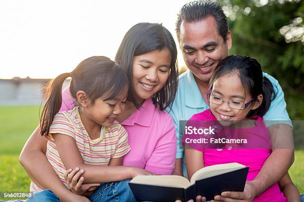 Reading The Bible As A Family Stock Photo - Download Image Now - Bible, Family, Reading